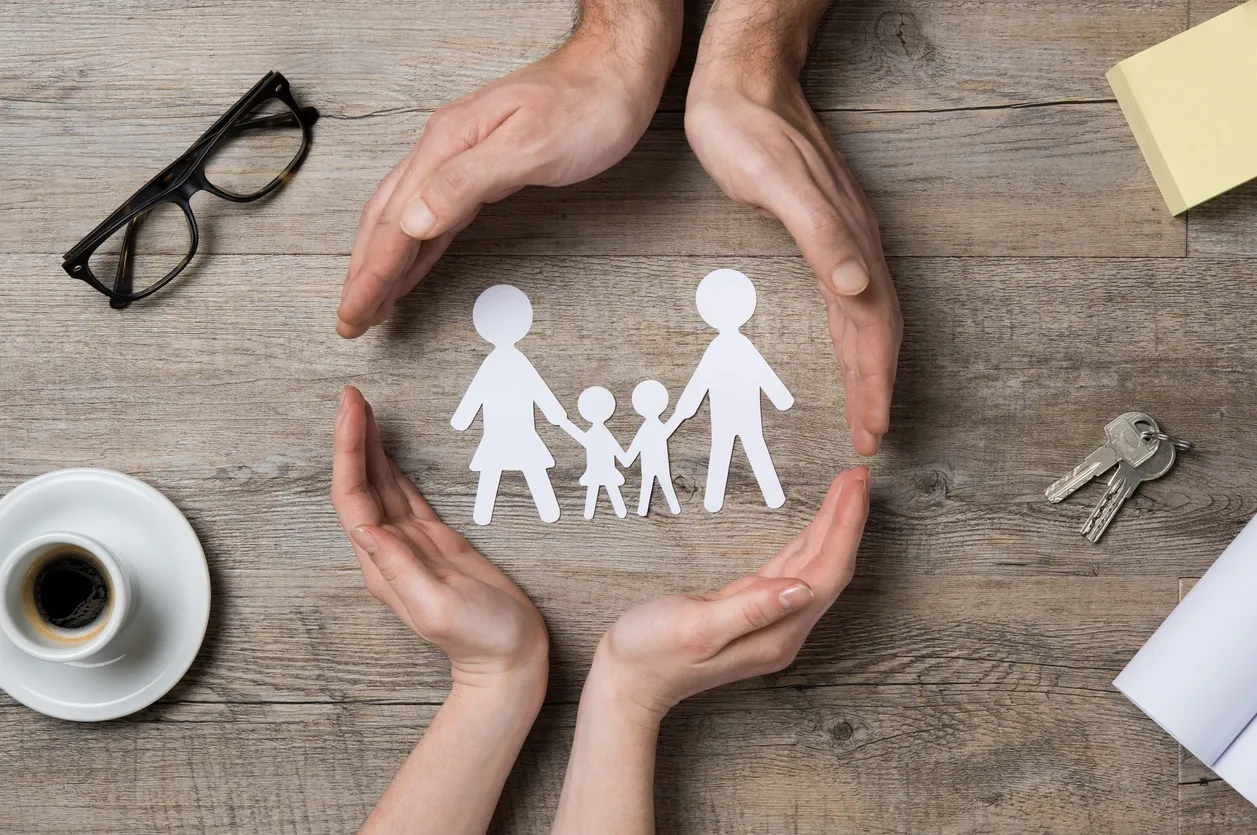 rs=w_1280 (16) A paper cut out of a family with hands around it.