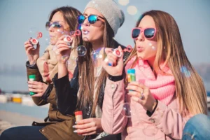 Three women blowing bubbles with soap bubbles.