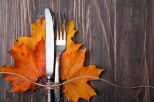 A fork and knife sitting on top of some leaves.