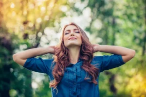A woman with her hands behind her head.
