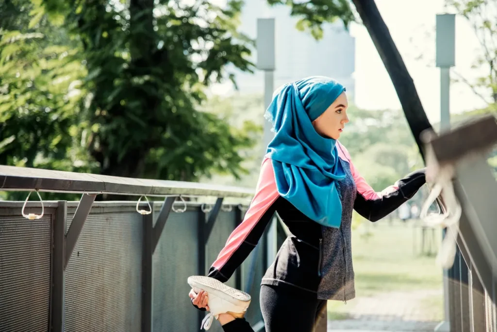 A woman in a hijab walking on the sidewalk.