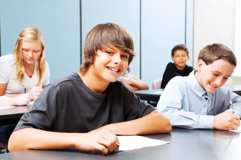 A group of people sitting at tables with papers.