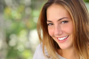 A woman with white teeth smiling for the camera.