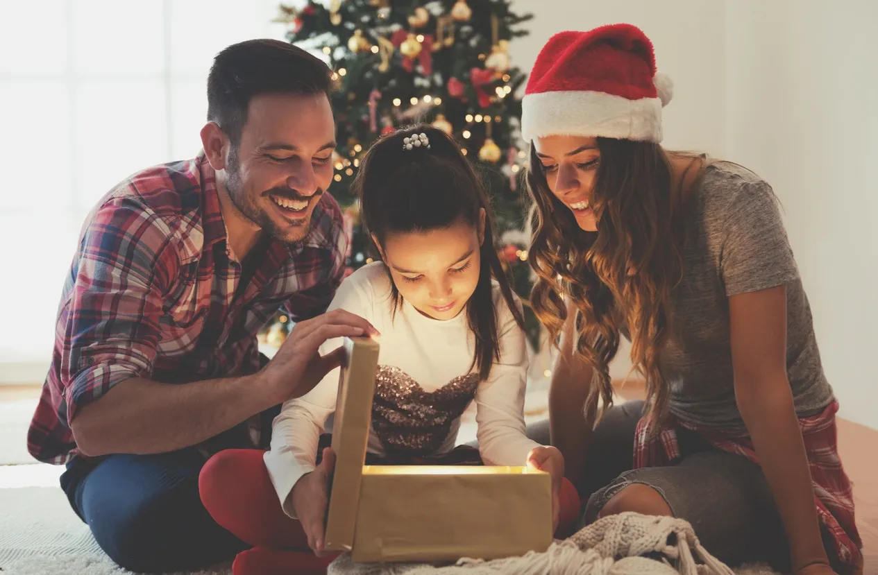 A family opening up a christmas present.
