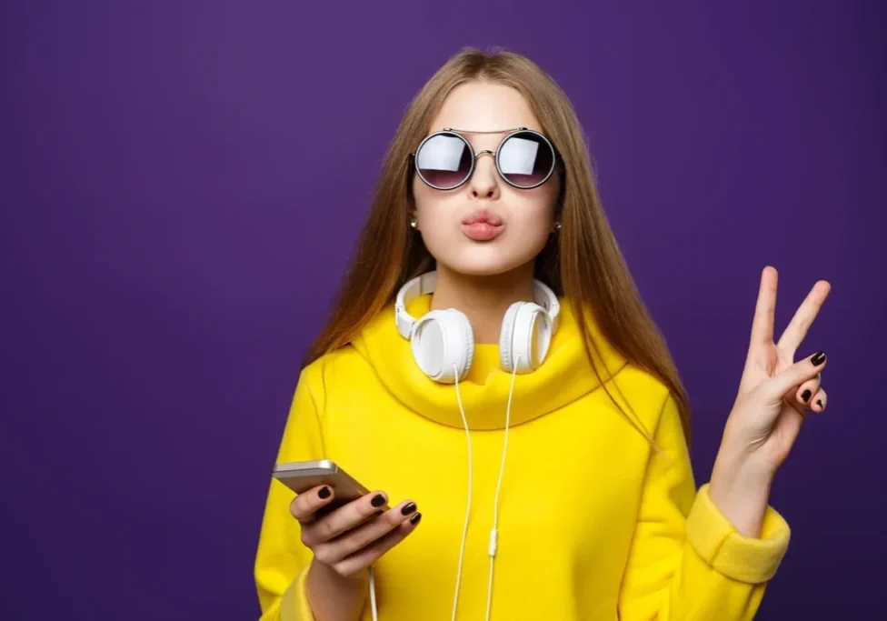 A woman wearing sunglasses and holding a cell phone.