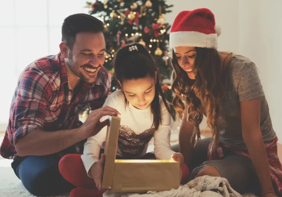 A family opening up a christmas present.