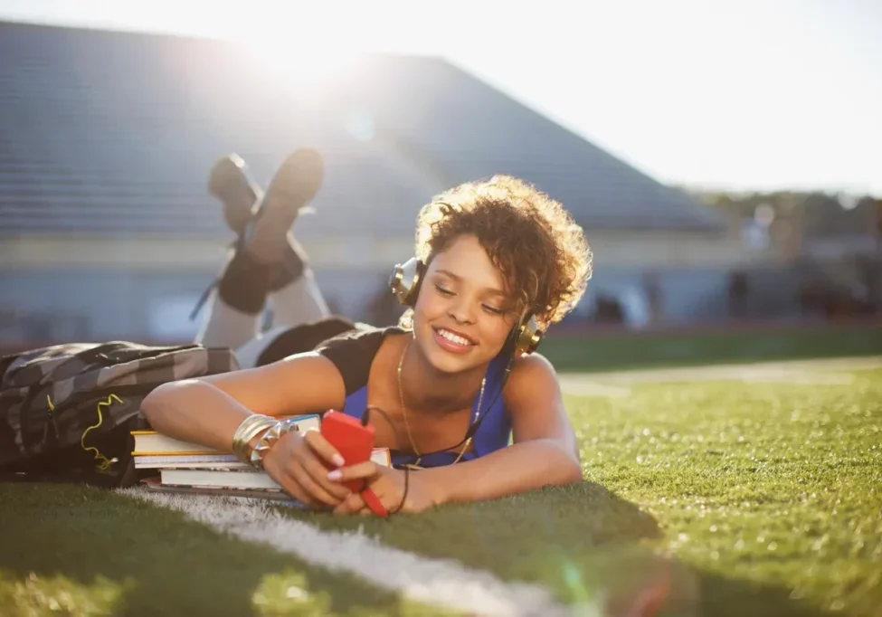 A woman laying on the grass with headphones